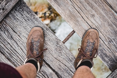 河下的木桥上穿着棕色鞋子的人